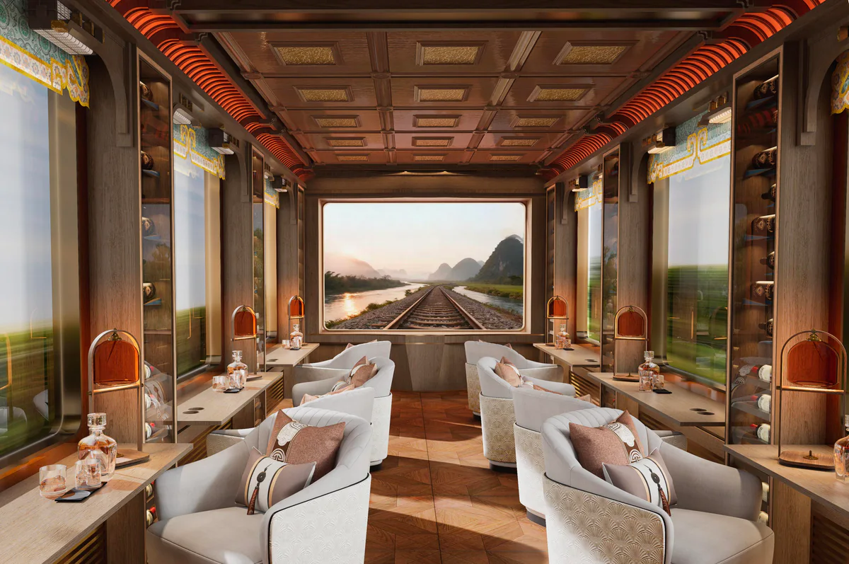 Panoramic design view of the Yunque observation lounge with cream armchairs, timber detailing and a large end display.